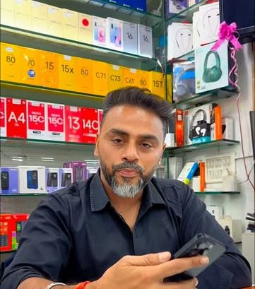 Sunny Rajani at the counter in front of shelves of phone boxes