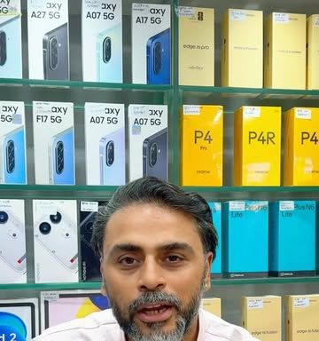 Sunny in front of a wall of Samsung and realme boxes